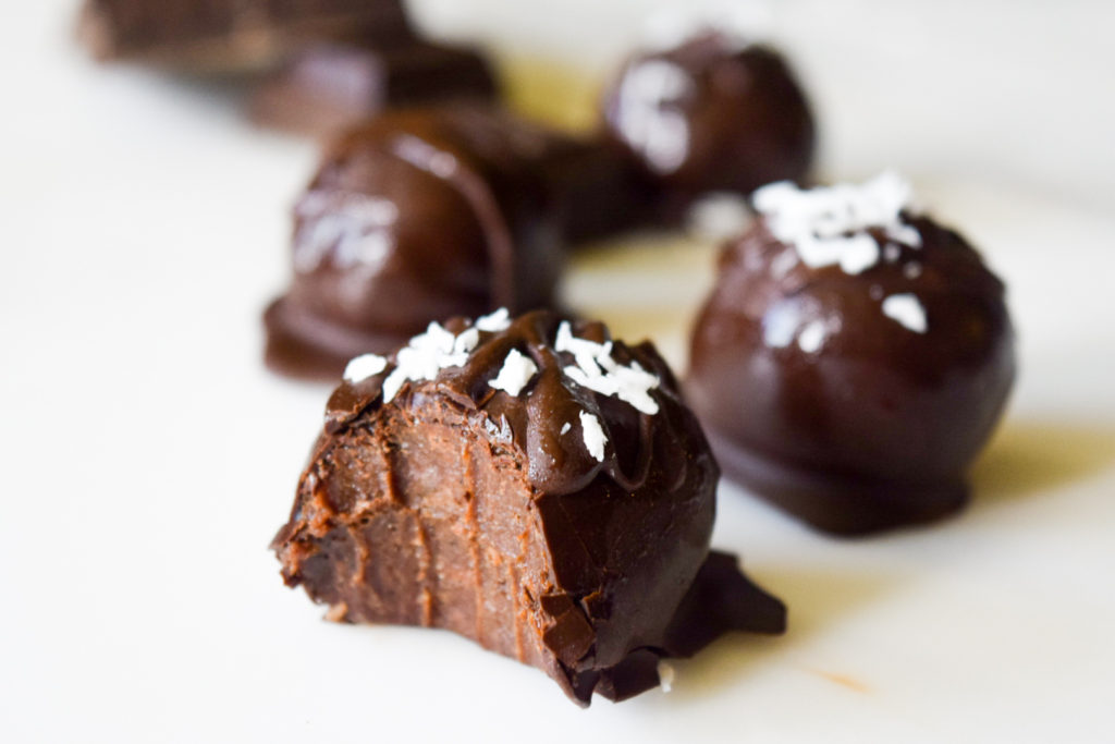 Decadent Brownie Truffle in foreground with a big bite out of it
