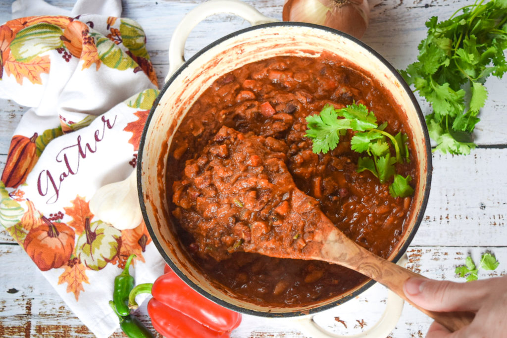 Huge vat of chili with fresh green cilantro and garlic